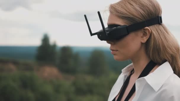 Ragazza in nero occhiali FPV e un pannello di controllo drone da corsa — Video Stock