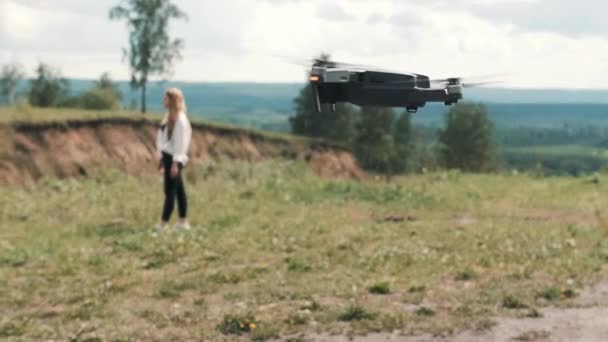 TOMSK, RUSIA - 23 de mayo de 2020: DJI Mavic Pro drone flotando en el aire y la niña en el fondo — Vídeos de Stock