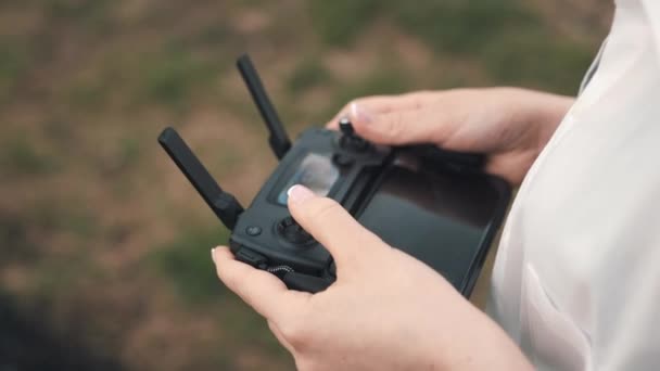 Mãos femininas segurando um controlador de um drone — Vídeo de Stock