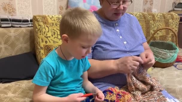 孙子和祖母坐在一起 学习编织 奶奶织了一条漂亮的开襟围巾 — 图库视频影像