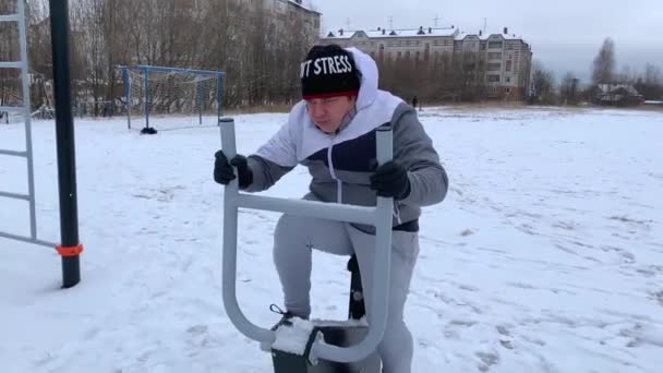 若い男が冬に野外運動自転車に従事している — ストック動画