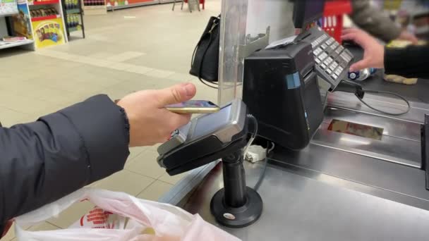 Ein Junger Mann Bezahlt Supermarkt Der Kasse Mit Dem Smartphone — Stockvideo