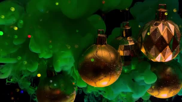 Gouden Glanzende Kerstballen Veelkleurige Sprankelende Bokeh Groene Inkt Het Water — Stockvideo