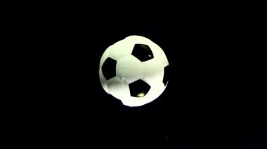 Futbol topu siyah bir uzay yıldızının arka planında kendi ekseni etrafında döner. Reklam futbolu yarışması kavramı. Dönen futbol topu.