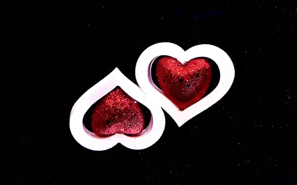 Două inimi albe cu inimi roșii în interior pe un fundal negru . — Fotografie, imagine de stoc