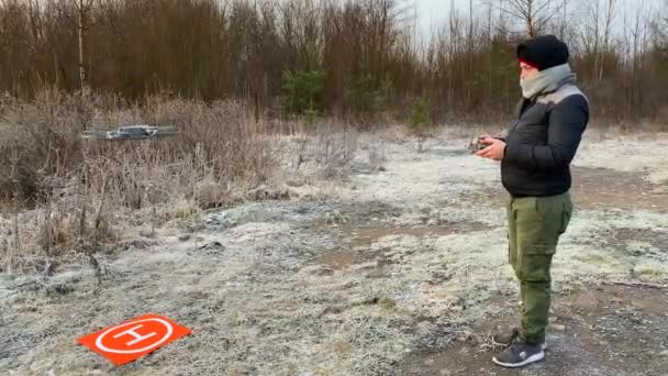 Młody Człowiek Kontroluje Drona Pomocą Pilota Lądowanie Quadrocoptera Specjalnym Lądowisku — Wideo stockowe