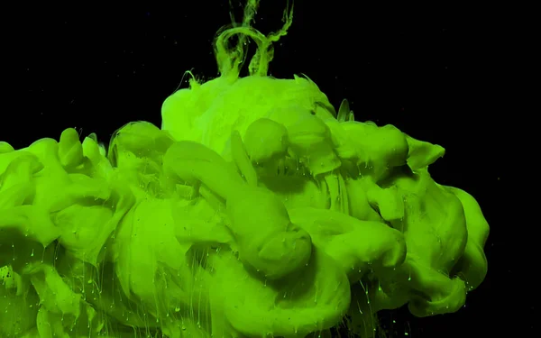 Green and yellow watercolor ink in water. Powerful explosion of