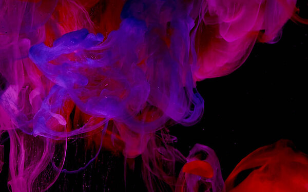 Beautiful color abstract background. Space background. Blue, red and white watercolor ink in water on a black background. Cool trending screensaver