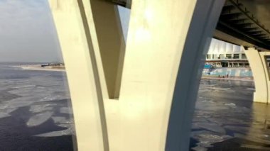 ST. PETERSBURG, RUSSIA - JANUARY 31, 2020: Aerial view of the winter Neva and the Lakhta center skyscraper. Gazprom headquarters. Drone flight over the city. Span under the bridge.