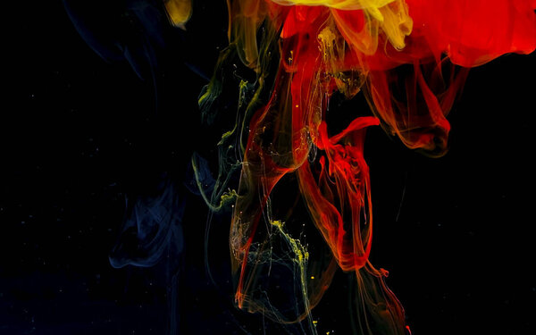 Black, yellow and red watercolor ink in water. Abstract background. Cool trending screensaver. A powerful explosion of colors.