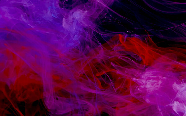 Scarlet watercolor ink in water on a black background. Colored space background. Abstract background. Stylish trending screensaver.