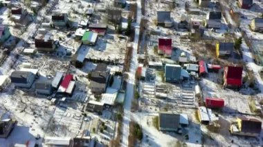 Güneşli bir kış gününde kırsal bir arazinin havadan görünüşü. Bir Rus köyünün üzerinde İHA uçuşu.