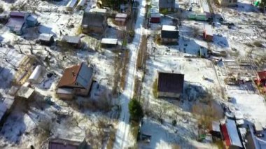 Güneşli bir kış gününde kırsal bir arazinin havadan görünüşü. Bir Rus köyünün üzerinde İHA uçuşu.