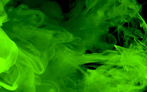Green watercolor ink in water on a black background. Cosmic magic background. Green abstract background. Cool trending screensaver.