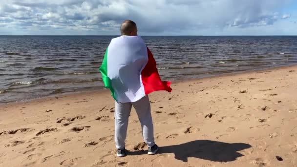 Młody Człowiek Trzyma Rękach Machającą Włoską Flagę Samotny Włoch Plaży — Wideo stockowe