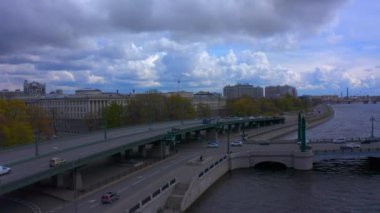 Bir Avrupa şehri, trafik, nehir ve gezinti alanı havadan görünüyor. Şehrin üzerinde İHA uçuşu.
