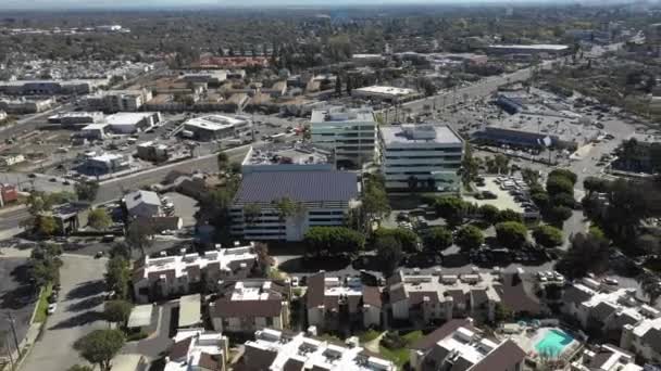 Vue aérienne, poursuite, drone autour d'un toit de bâtiments, recouvert de panneaux solaires, par une journée ensoleillée, à Long Beach — Video