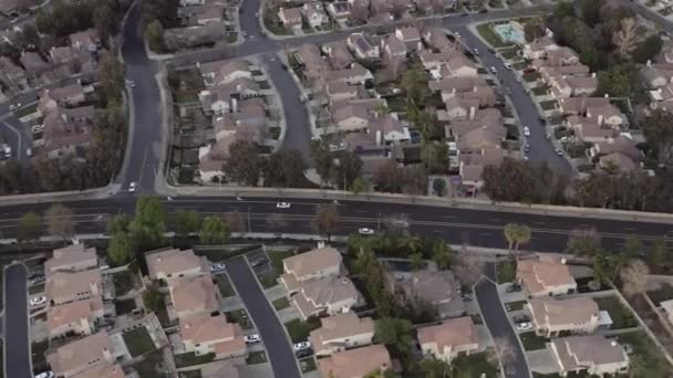 Vista aérea seguindo carro branco dirigindo pelas ruas suburbanas da cidade, drone — Vídeo de Stock