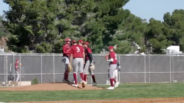 Středoškolský baseballový tým zamíří na kopec, aby si promluvil s nadhazovačem o další hře — Stock video