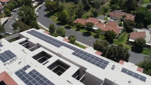 Aire descendiendo sobre Laguna Hills complejo de condominios paneles solares en la azotea energía verde — Vídeos de Stock