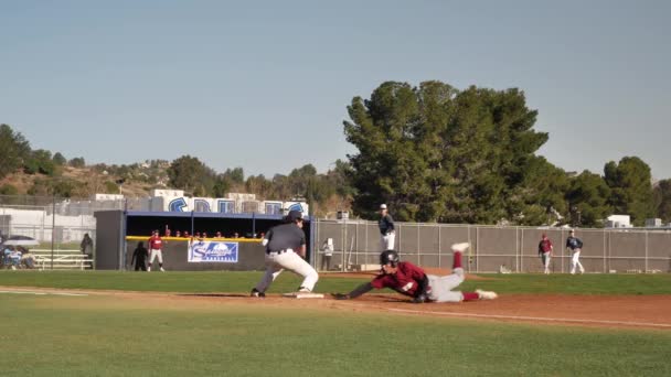 High school Baseball spel, kastare kastar till första basen för att plocka bort bas löpare, slow motion — Stockvideo