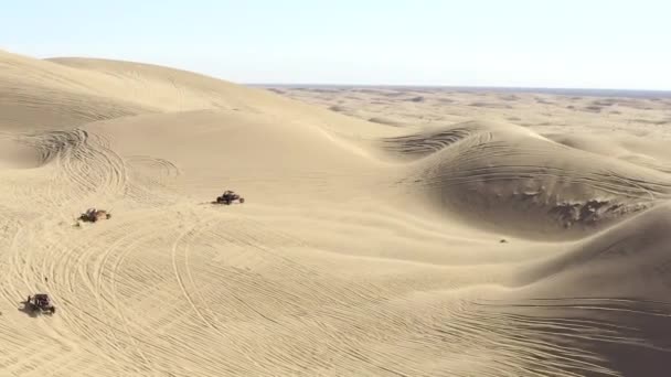 Vista aerea seguire, tutti i veicoli del terreno ATV nel deserto guida su dune di sabbia — Video Stock