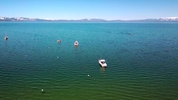 Empuje aéreo hacia adelante, imágenes sobre el lago Tahoe y barcos, día soleado — Vídeo de stock