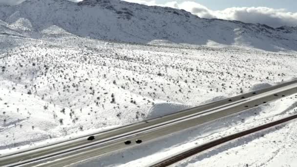 Carretera a través de la montaña cubierta de nieve, vista aérea del camión lateral — Vídeos de Stock