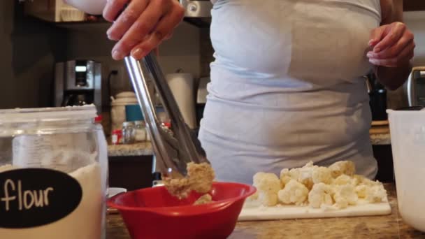 요리할 준비를 하기 위해 꽃양배추를 반죽에 담그는 여자 요리사 — 비디오