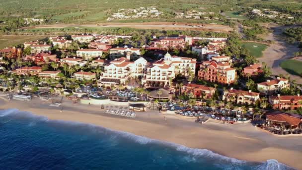 Воздушная прогулка по набережной Кабо-Сан-Лукас, кондосы и виллы у песчаного пляжа — стоковое видео