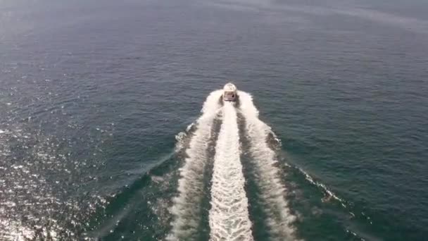 Motoscafo Vela su calmo oceano rendendo sentieri d'acqua, Tracking Aerial — Video Stock
