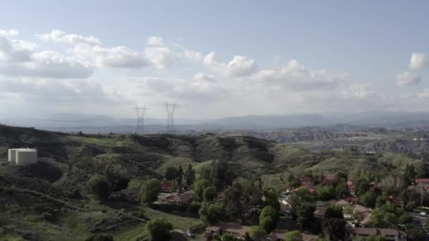 Vista aérea sobre bairro de casa com linhas de energia, montanhas e nuvens — Vídeo de Stock