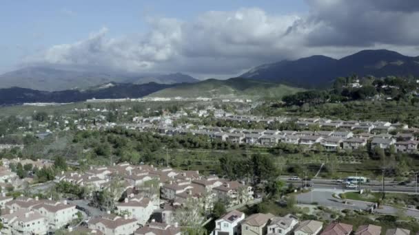 Descending aerial of neighborhood of homes in suburb of Los Angeles, dark clouds — Stock Video