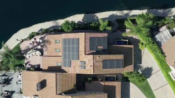 Solar panels installed on luxury homes in wealthy suburb beside lake, aerial — Stock Video