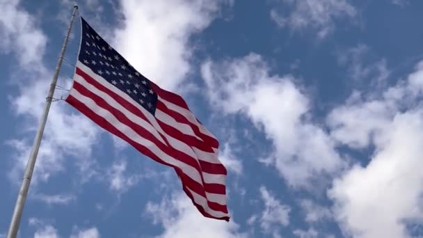 Bandera Americana ondeando en el viento con nubes y cielo en el fondo, de cerca — Vídeos de Stock