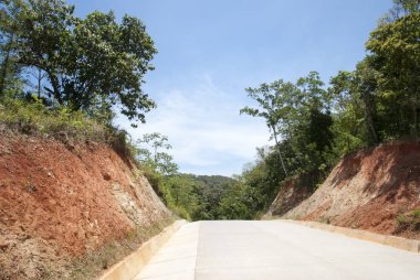 Roatan Adası 'nda kırmızı renkli zemin üzerinden inşa edilen yol (Honduras).