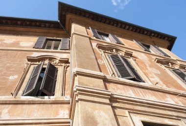 Roma 'da pencereleri açık olan turuncu renkli bina (İtalya).