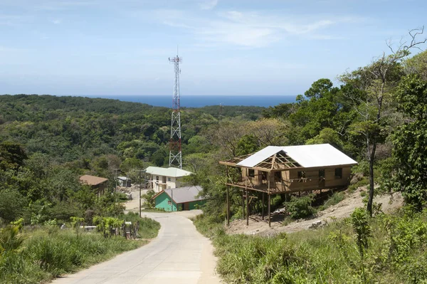 丘の下に続く村道の眺めと背景の通信塔 ホンジュラス — ストック写真