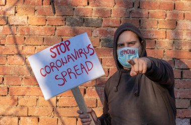 Bayrağı olan adam Coronavirus 'u durdurun. İnsan protestoları, Corona virüsüyle savaşmak için hükümetleri aramak. Bilim insanlarını salgını durdurmaya teşvik eder. Maskeli kişi protesto ediyor..