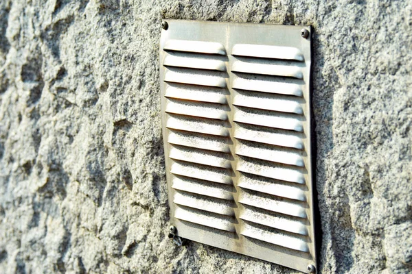ventilation hole with grille on the facade of the house