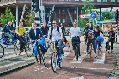 NEDERLAND, AMSTERDAM - 6 AĞUSTUSTUSTOS 2019: şehirde bisikletli insanlar oh sokak, Avrupa, Amsterdam
