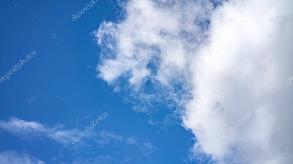 blue sky with white swirling clouds