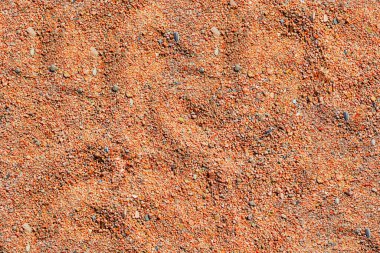 kırmızı rengin kumlu, düz olmayan yüzeyi, pürüzsüz dokusu