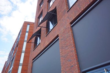 Bakış açısına göre modern bir kırmızı tuğla binanın pencereleriyle ön cephe