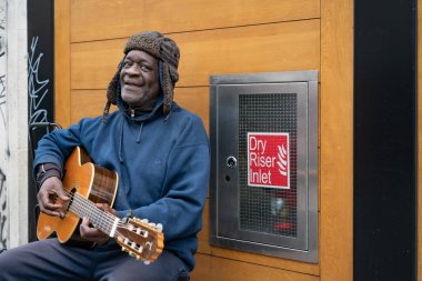 LONDON - 3 Mart 2020: Yaşlı siyah adam bir şehir caddesinde gitar çalıyor