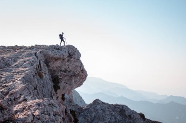 Uçurumun kenarındaki dağda yürüyüş yapan adam..