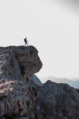 Uçurumun kenarındaki dağda yürüyüş yapan adam..