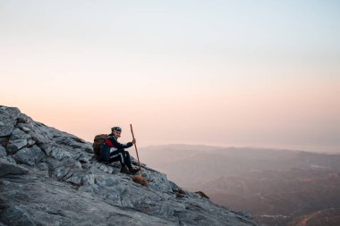 Uçurumun kenarındaki dağda yürüyüş yapan adam..