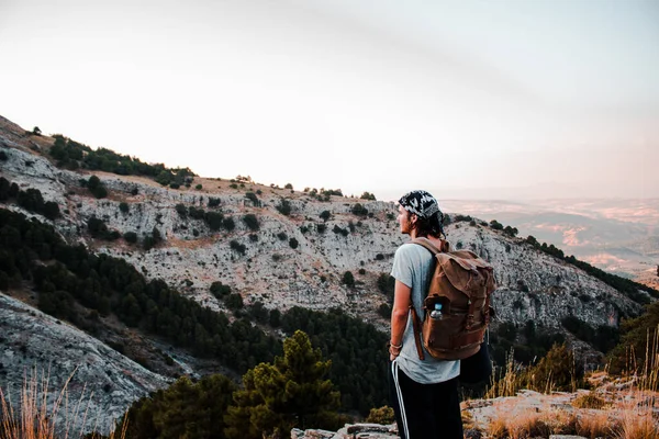Kahverengi sırt çantalı bir adam yürüyüş yapıyor..