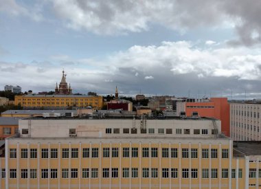 Huzursuz mavi gökyüzü Rusya 'daki İzhevsk şehrinin binaları ve yapıları üzerinde asılı bulutlarla